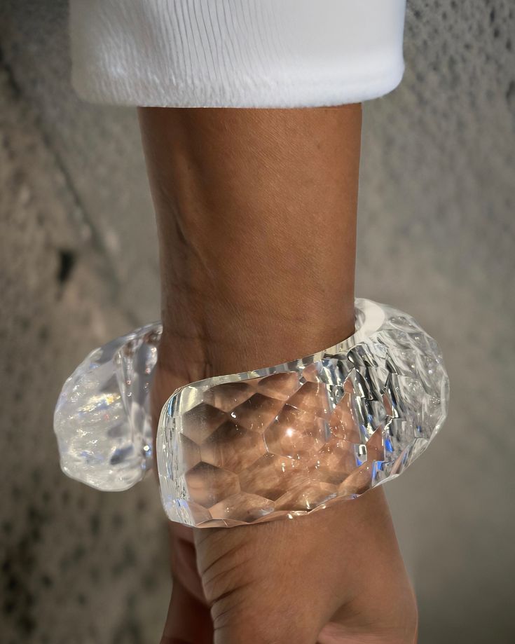 This Croc lucite cuff bracelet showcases a rounded and continuous design, entirely hand-sculpted for a unique and high-quality piece. Made with exquisite craftsmanship, it adds a touch of elegance and sophistication to any outfit. Expertly crafted and designed for durability, this bracelet is a must-have for any fashion enthusiast. Lucite Bangle Bracelets As Gift, Lucite Bangle Bracelet As Gift, Lucite Bangle Bracelet For Gift, Handmade Elegant Clear Bracelets, Elegant Handmade Clear Bracelets, Elegant Plastic Jewelry For Parties, Elegant Adjustable Carved Bangle, Elegant Clear Bangle Jewelry, Modern Clear Bracelet Jewelry