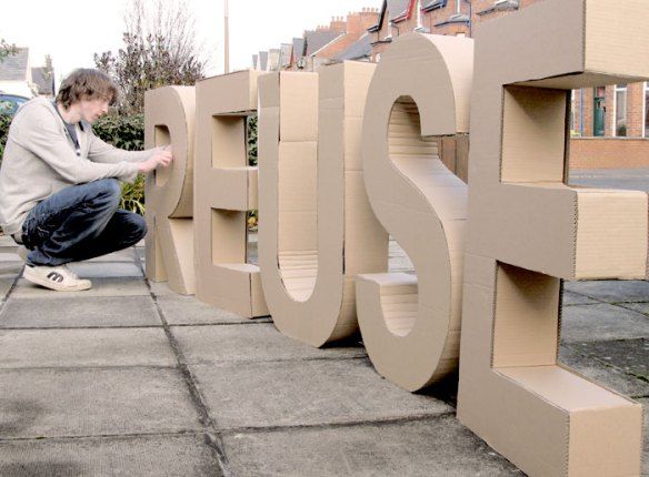 a man kneeling down next to a cardboard sign