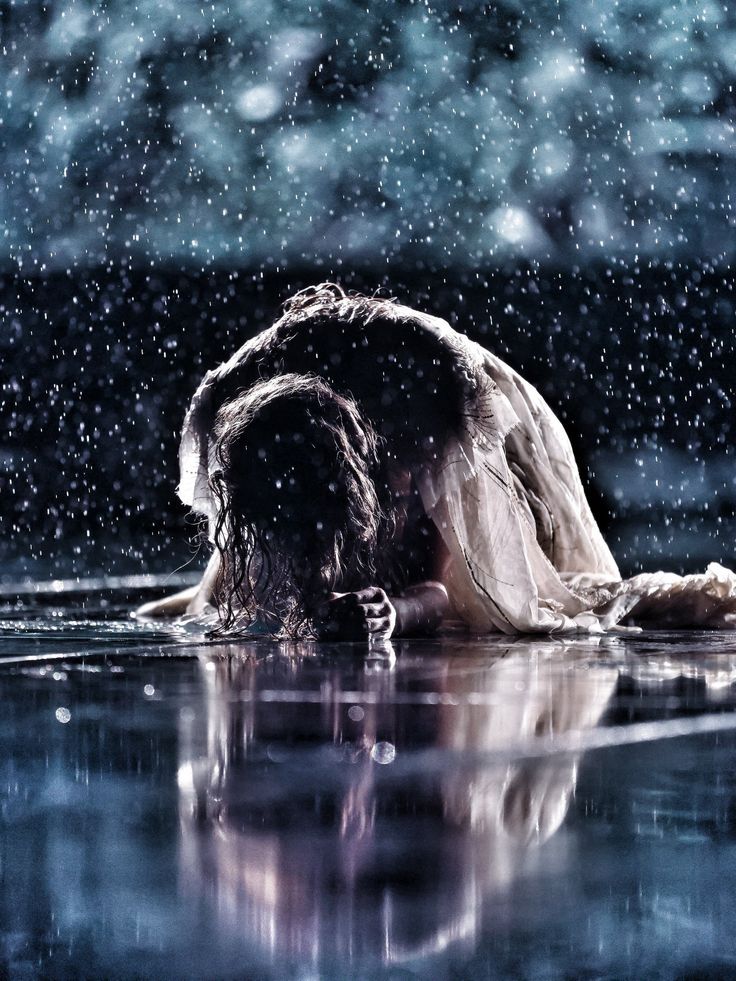 a woman is floating in the water with her head down and she's covering her face