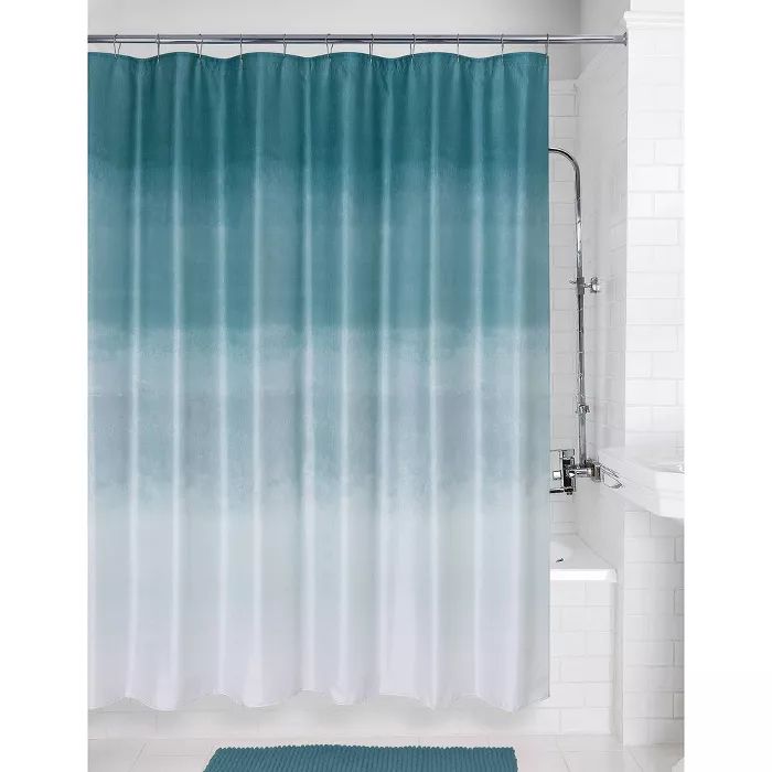 a shower curtain with blue and white ombrettas on the side in a bathroom