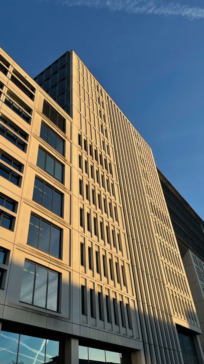 a tall building with lots of windows next to a parking meter on the side of it