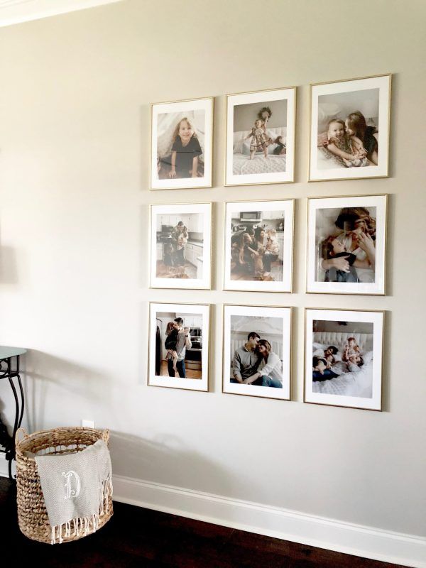 a wall with many pictures on it and a wicker basket in front of it