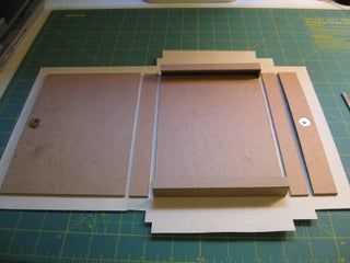 cut out pieces of cardboard sitting on top of a cutting board