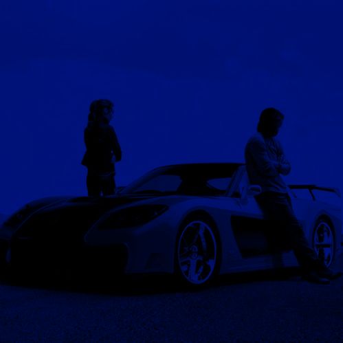 two people standing next to a car in the dark