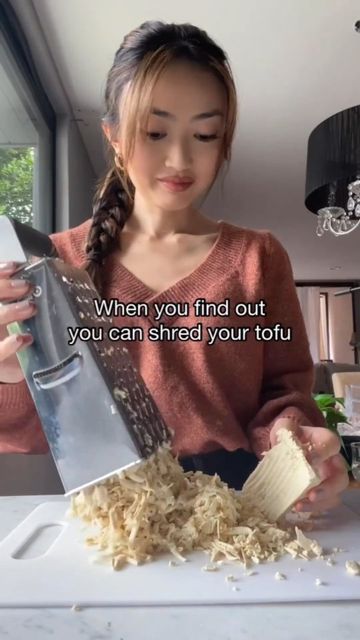 a woman is grating some food with a grater in her hand and the words, when you find out, you can shred your tofu