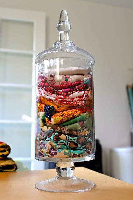 a glass container filled with lots of different types of fabric