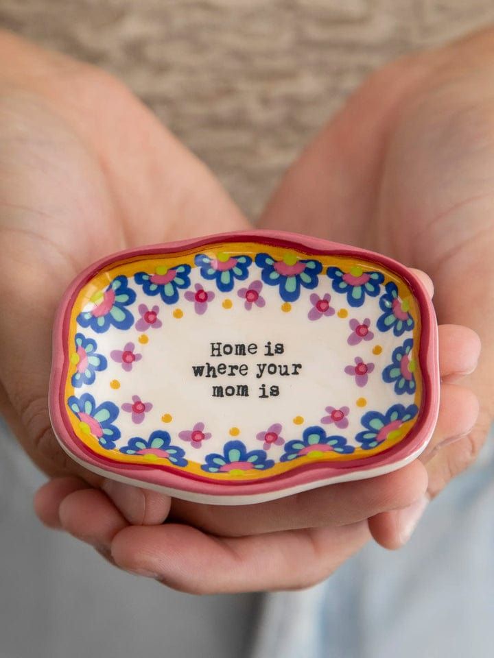 a person holding a small bowl with the words, home is where your mom is