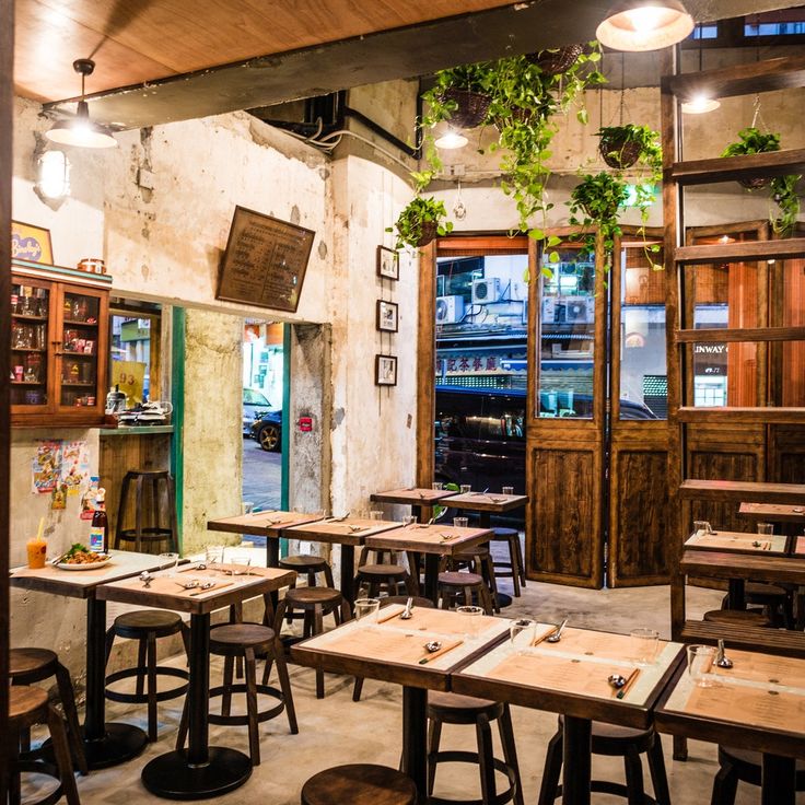 an empty restaurant with wooden tables and stools