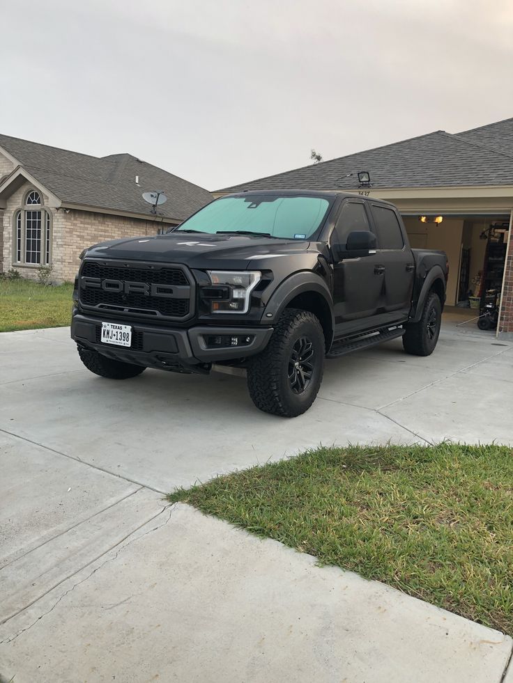 a black truck parked in front of a house