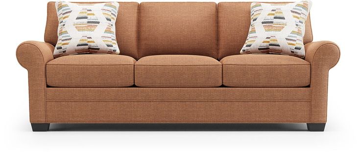 a brown couch with two pillows on it's back and the seat facing forward