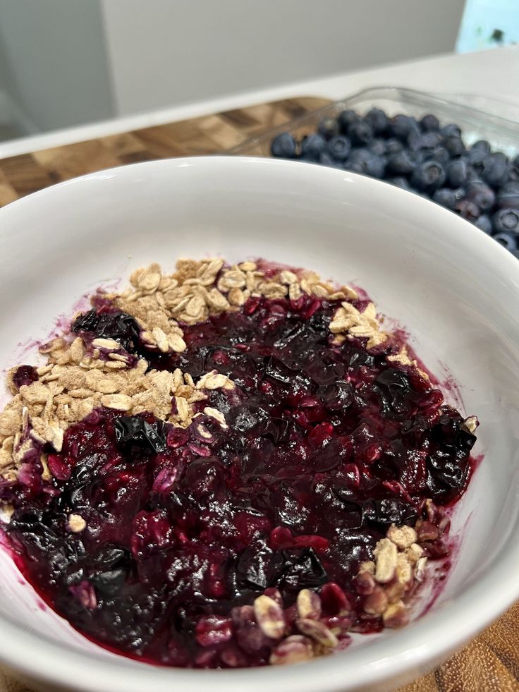 a white bowl filled with blueberries and granola