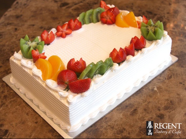 a white cake topped with fruit on top of a counter