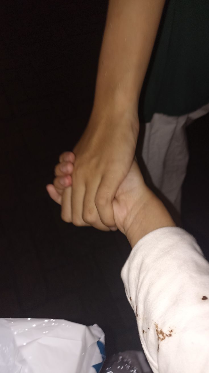 a close up of a person holding the hand of another person