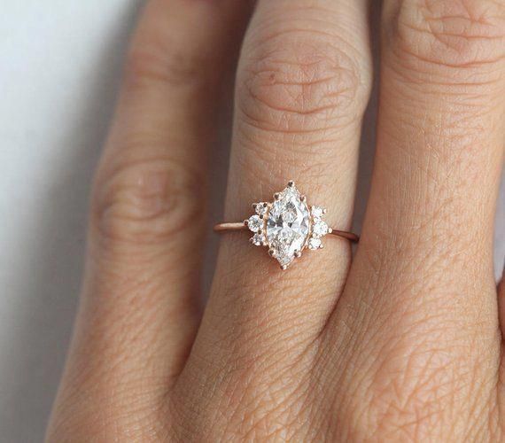 a woman's hand with an engagement ring on her finger, showing the center stone