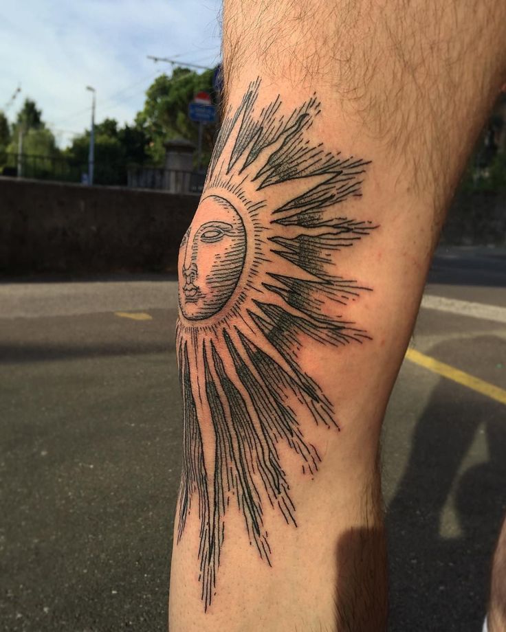 a person with a sun tattoo on their leg