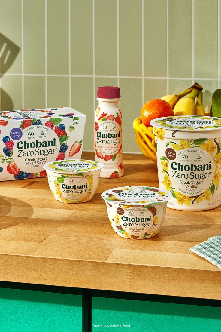 an assortment of yogurt sits on a counter top next to fruit and other items