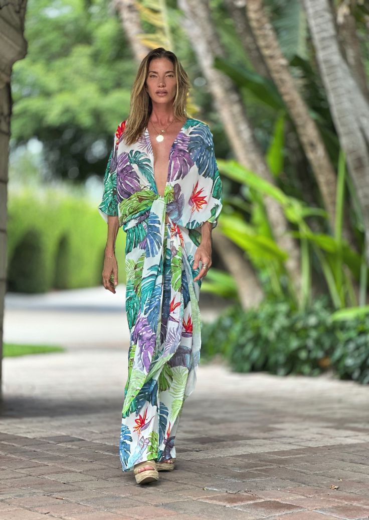 ERTE KAFTAN TROPICAL Elevate your wardrobe with our sophisticatedly designed Erte Kaftan featuring a tropical pattern. This versatile garment can be effortlessly style over your bikini, dress, shorts, or pants, and elegantly fastened in the front for a chic and upscale look. Open front ¾ sleeves Thigh high slits on sides 60" length 100% Chiffon Hand Wash or Delicate Cycle and Hang Dry The print is an original Ramona La Rue hand painted by the designer and transferred to fabric. Every garment has Summer Floral Print Cover-up For Day Out, Tropical V-neck Swimwear With Tropical Print, Beachwear Floral Print Cover-up For Day Out, Printed Beachwear Cover-up For Day Out, Beach Party Tropical Print Cover-up, Summer Tropical Print Poolside Cover-up, Floral Print Vacation Cover-up, Floral Print Beachwear Swimwear For Day Out, Floral Print Swimwear For Beach Day Out