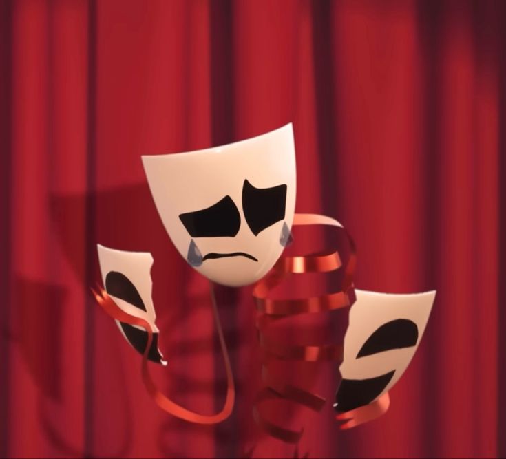 three masks with faces on them sitting in front of a red curtain and some wires