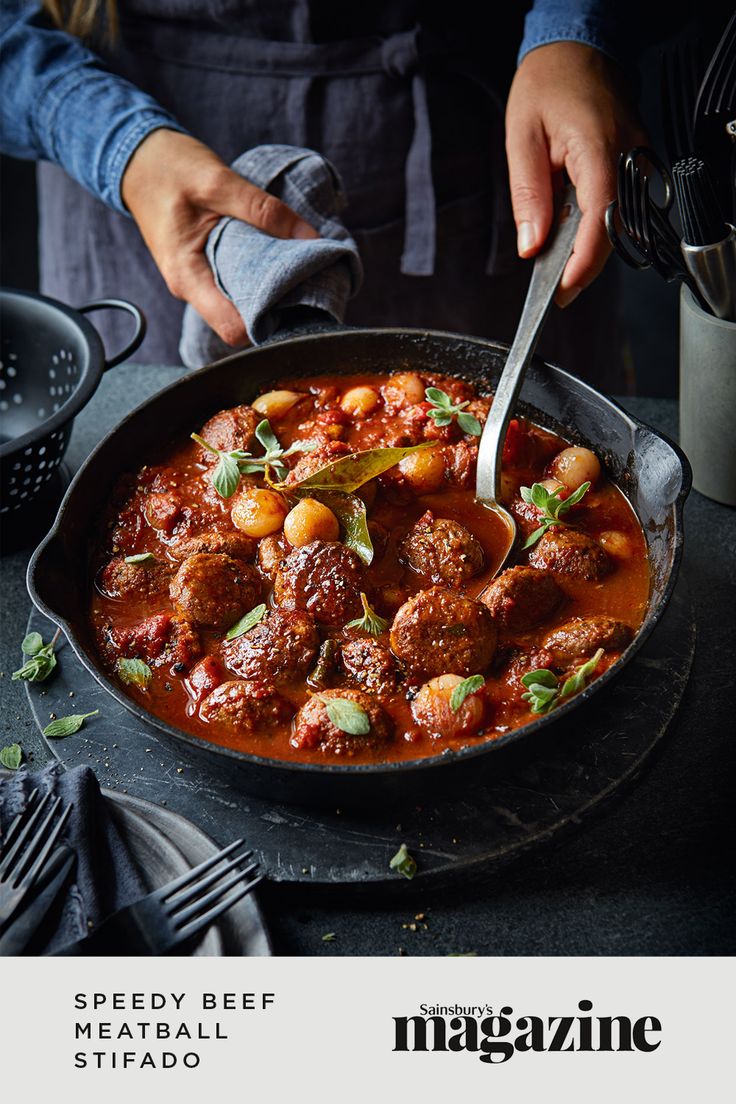 a person is cooking some meatballs in a skillet with a spoon and fork