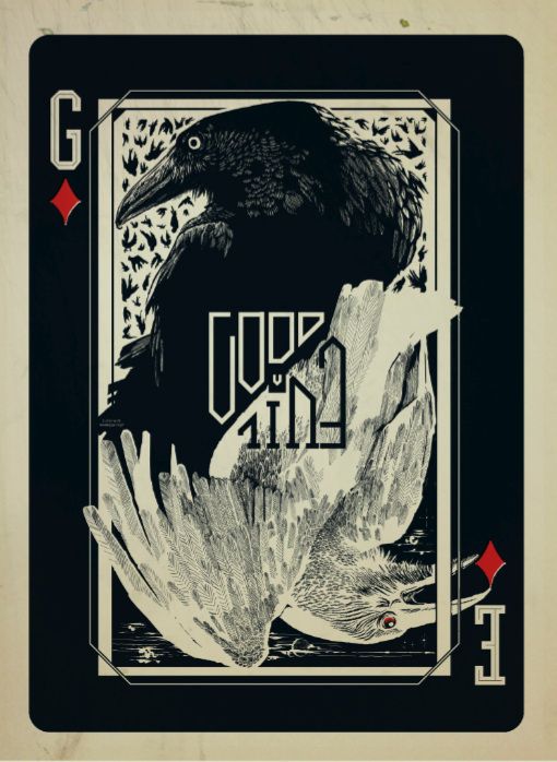 a black bird sitting on top of a playing card