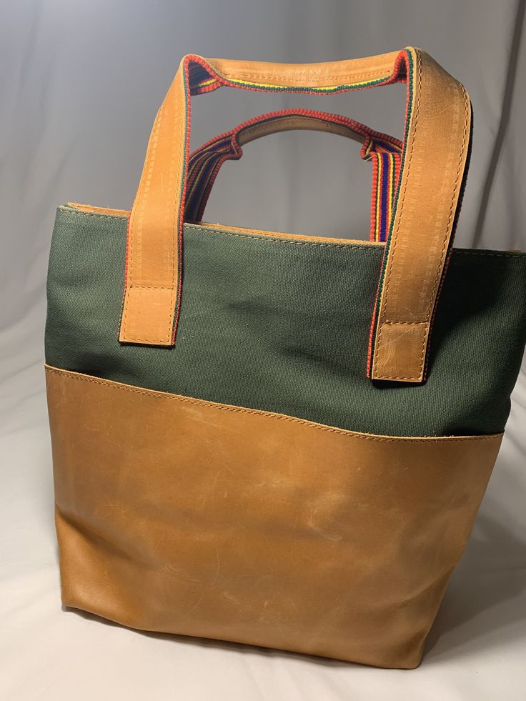 Genuine Leather Tote along Bag. A mixed media bag big enough for all the essentials. With an interior zip pocket for added storage and three exterior pockets for easy access. Material- Genuine Leather and Canvas Rectangular Leather Bucket Bag With Zipper Closure, Pouch Bags With Zipper Pocket For Errands, Green Rectangular Bucket Bag With Zipper Closure, Leather Bucket Bag With Zipper For Daily Use, Green Rectangular Bucket Bag With Zipper, Leather Satchel Laptop Bag With Zipper Pocket, Modern Satchel With Zipper Pocket For Daily Use, Modern Satchel With Zipper Pocket For Errands, On-the-go Bag With Zipper Pocket And Pouch Shape