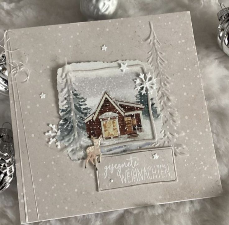 a christmas card with an image of a house in the snow and ornaments around it