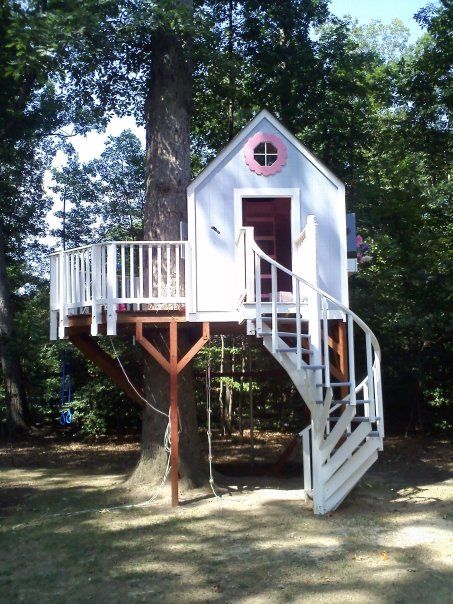 a white tree house with stairs to the top