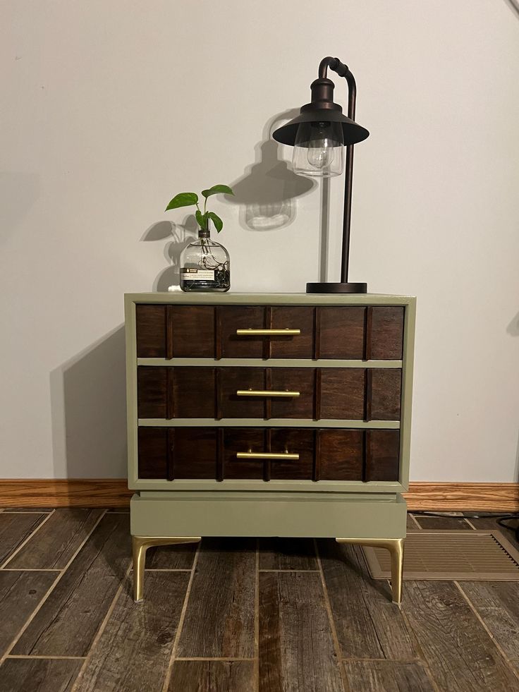 a dresser with drawers and a lamp on top