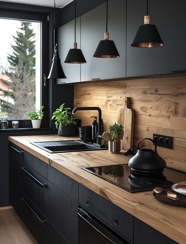 a kitchen with black cabinets and wooden counter tops, hanging lights above the sink and potted plants