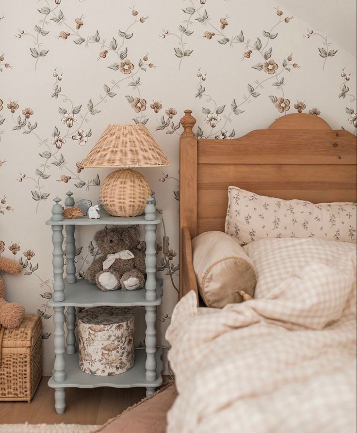 a bed room with a neatly made bed and a teddy bear on the night stand