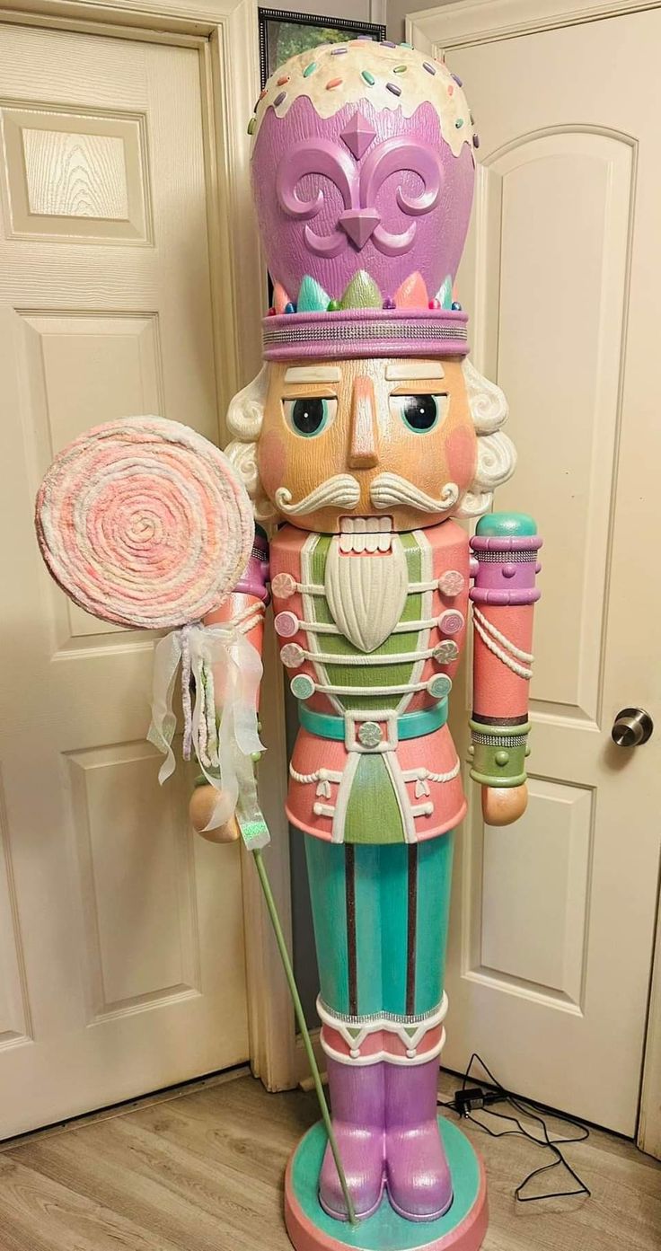 a large nutcracker holding a candy lollipop