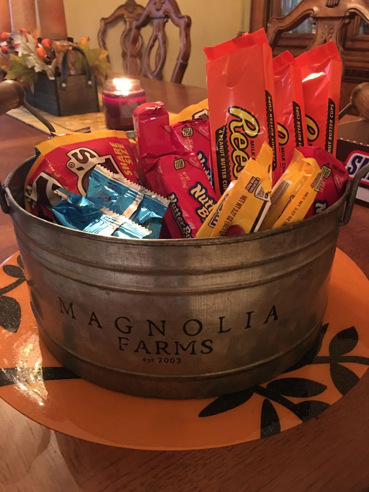 a metal bucket filled with candy bars on top of a table