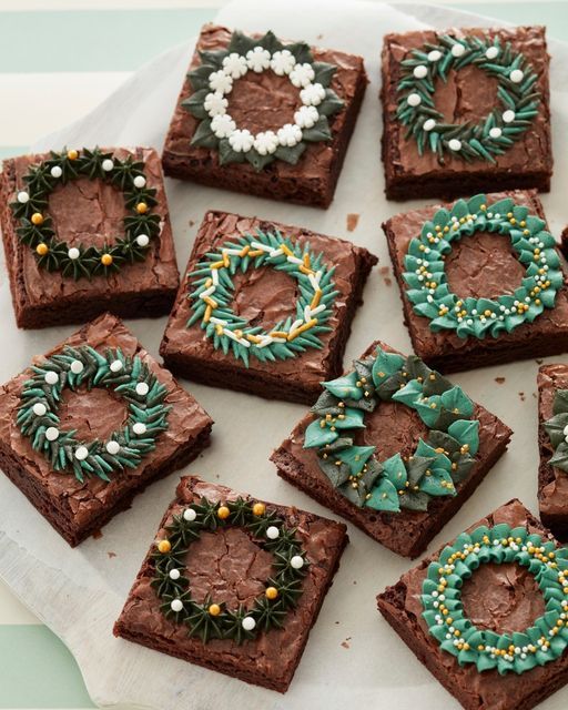 twelve square brownies decorated with green and white decorations