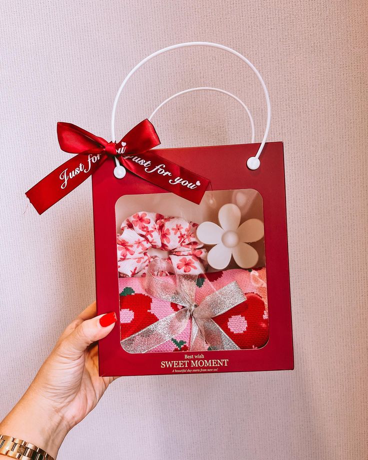 a hand holding up a card with a red bow on it that says sweet moment