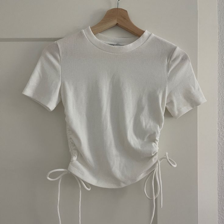 White Zara Cropped Tee! Ribbed With Ruched Sides That Can Be Tied Into Bows. Brand New, Never Worn, No Tags. Size Small. Stretch Tops With Drawstring For Day Out, Stretch Drawstring Tops For Day Out, White Drawstring Crew Neck Top, White Crew Neck Top With Drawstring, Fitted Cotton Tops With Drawstring, Casual Drawstring Crop Top, Cotton Drawstring Crew Neck Top, Cotton Crew Neck Top With Drawstring, Cotton Ruched Fitted Top