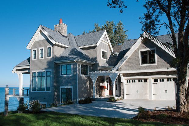 a large gray house sitting next to the ocean