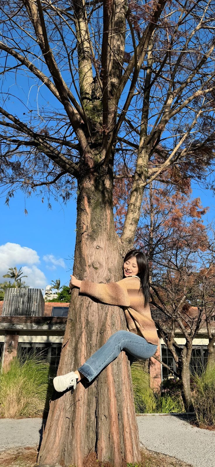 a woman sitting on the trunk of a tree