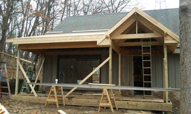 a small house being built in the woods with wooden steps leading up to it's front door