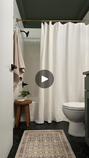 a white toilet sitting next to a bath tub in a bathroom under a shower curtain