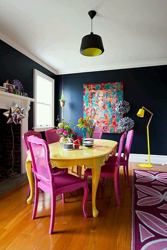 a yellow table and pink chairs in a room with blue walls, hardwood floors and wooden flooring