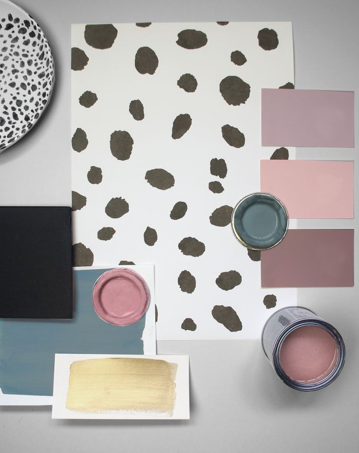 a table with paint, paper and other items on it that include pinks, browns, and black spots