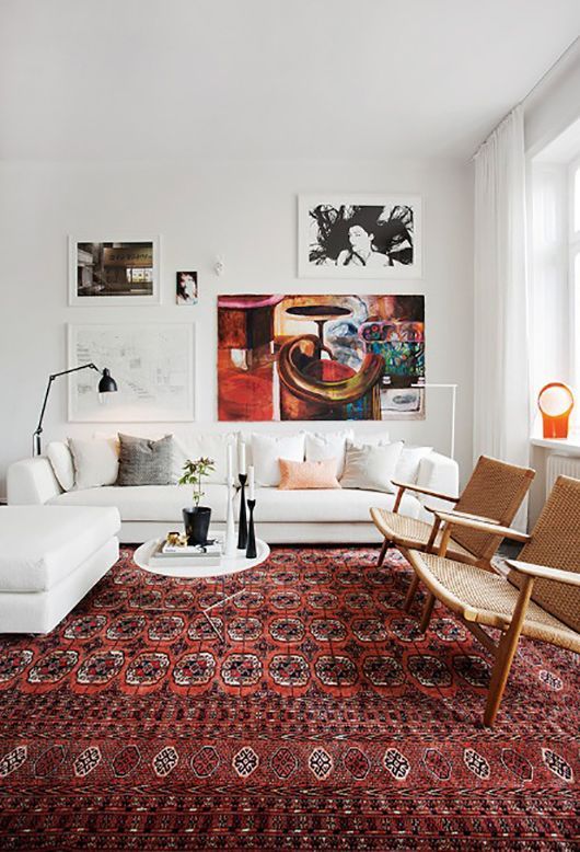 a living room filled with white furniture and lots of pillows on top of a rug