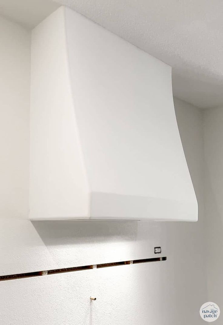 a white stove top oven sitting inside of a kitchen next to a wall mounted light