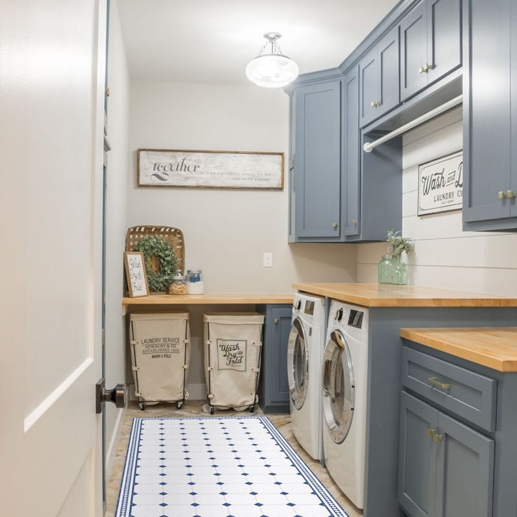 a washer and dryer in a laundry room next to blue cabinets with drawers