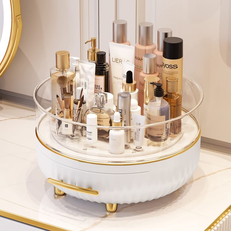 an assortment of beauty products in a clear container on a white counter with a gold rim