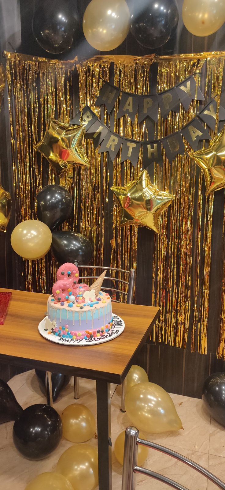 a table topped with a cake covered in pink frosting and sprinkles