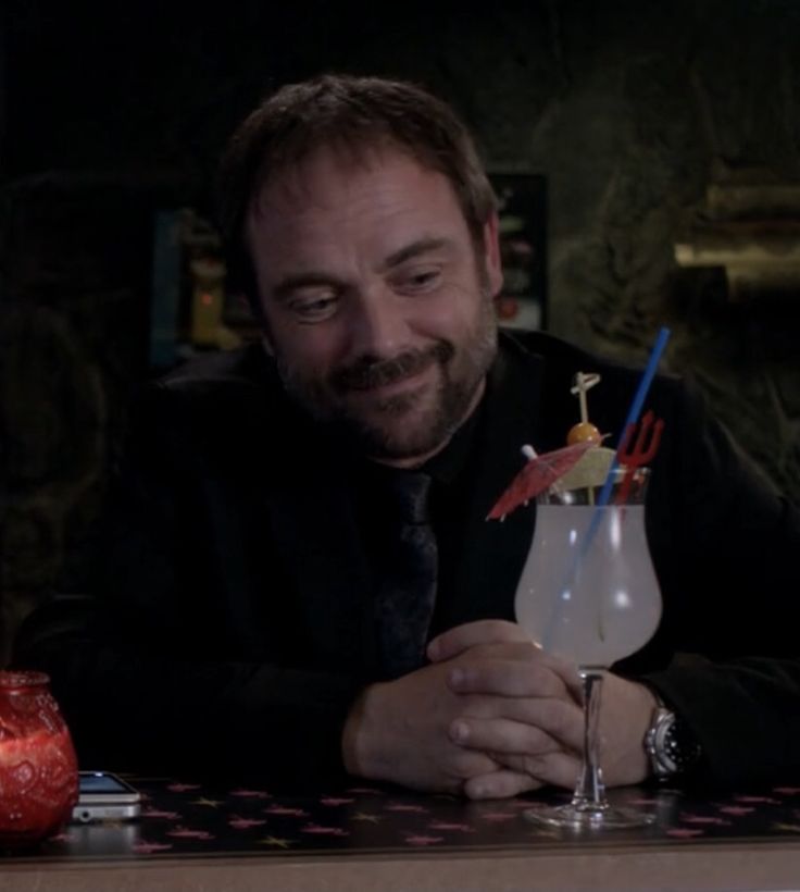 a man sitting at a bar with a drink in his hand