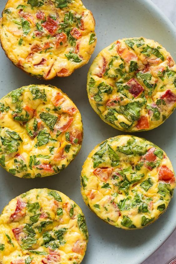 frittata muffins with cheese and spinach are on a white plate