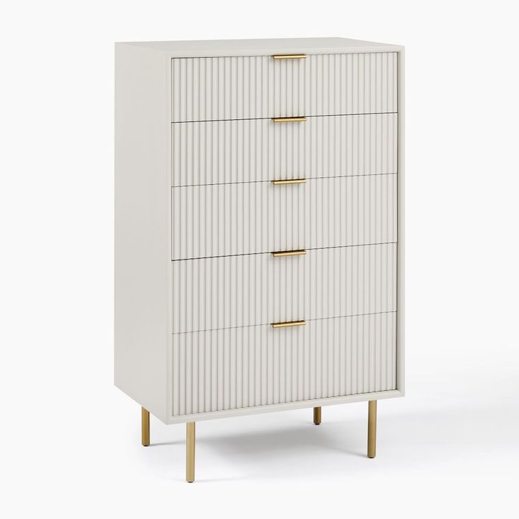 a white chest of drawers with gold handles