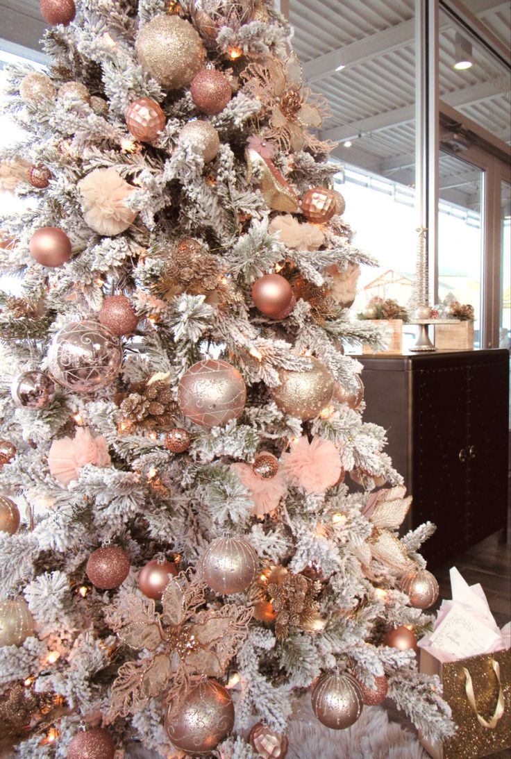 a white christmas tree with pink and gold ornaments